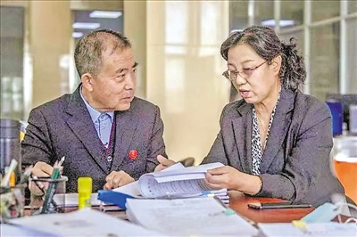 盐池县人民法院两位特邀调解员在讨论案件。